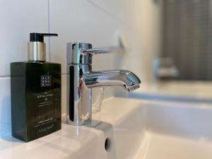 un lavandino in bagno con rubinetto e una bottiglia di sapone di B&B van Basten Batenburg a Slenaken Altre 9 foto