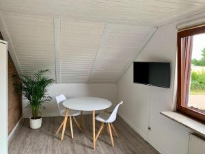 a room with a table and two chairs and a tv at Haus Deepensoll 39 Ankerplatz in Pelzerhaken