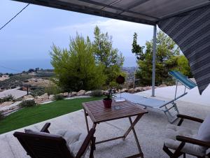 a table and chairs on a patio with a view at Altheas Maisonettes in Xylokastron