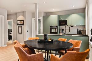 a kitchen with a black table and chairs at Odda Central Apartment in Odda