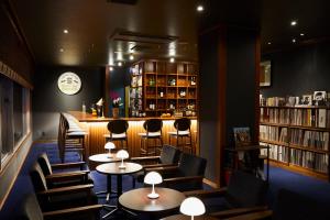 a bar with tables and chairs in a library at Ryokan Oomuraya in Ureshino