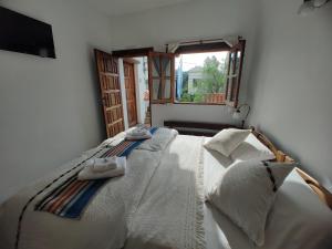 a bedroom with a white bed with a window at La Posta Tigre in Tigre +11 photos