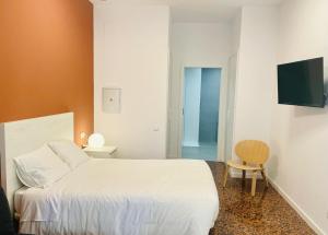 a bedroom with a white bed and a chair at Apartahotel Espai Verd Benimaclet in Valencia