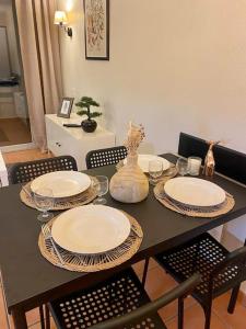 a dining room table with plates and chairs at Appartement sur le golf in Arcangues