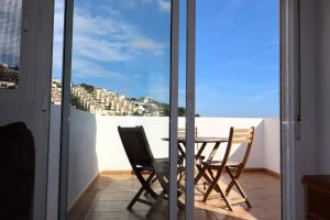 a table and chairs on a balcony with a view of a city at Montemar LEK in Peñíscola