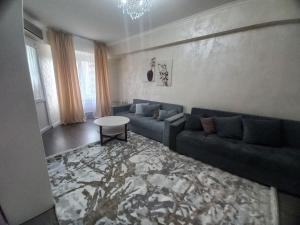 Una sala de estar con un sofá azul y una mesa. en On Arbat the Center of Almaty, en Almaty 5 fotos más
