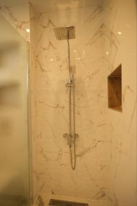 a shower with a shower head in a bathroom at Апартамент за гости Симона in Smolyan