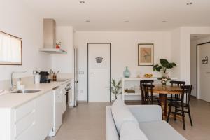 a kitchen and living room with a couch and a table at La Figuera in Ultramort