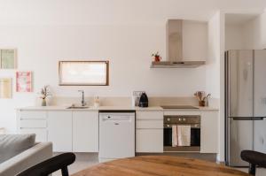a kitchen with white cabinets and a wooden table at La Figuera in Ultramort