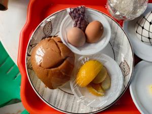 a plate of food with eggs and fruit on a tray at Da White Residence Makerere in Kampala