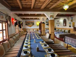 a long dining room with long tables and chairs at Maison D'hôte La Vallée Des Figues in Tamellalt
