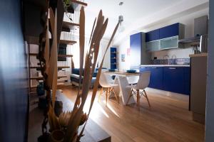 una cucina con armadi blu, tavolo e sedie di La Casa di Oliviero a Vetralla