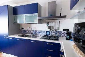 una cucina con mobili blu e un lavandino di La Casa di Oliviero a Vetralla Altre 18 foto