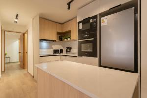 cocina con encimera blanca y nevera en Elegant 2BR Experience Las Condes in Style, en Santiago