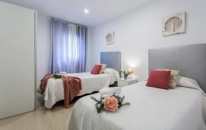 a bedroom with two beds with flowers on them at El Balneario in Cádiz