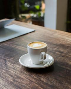 a cup of coffee sitting on a wooden table at Zajazd Rest in Przemyśl