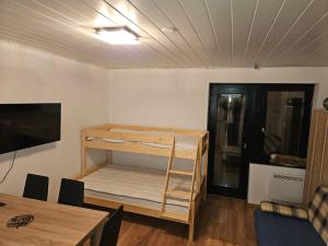 a room with a bunk bed in it with a table at Apartma Rogla Gaber 63 in Zreče