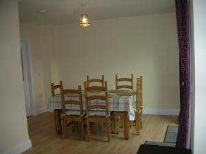 a dining room with a table and four chairs at 18 Carraig Naofa in Bantry