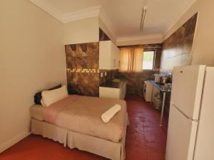 Una pequeña habitación con una cama y una nevera. en Vivo Lodge, en Vivo