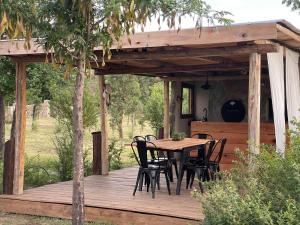 a wooden deck with a table and chairs on it at Las Quimeras in Nono
