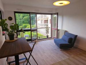 un soggiorno con una sedia blu e un tavolo di Vu parc, détendez vous au calme ! a Fontenay-sous-Bois Altre 14 foto