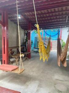 a room with hanging hammocks in a building at Aconchego em Gravatá in Gravatá