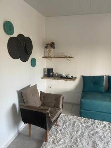 a living room with a couch and a blue chair at Aconchego em Gravatá in Gravatá