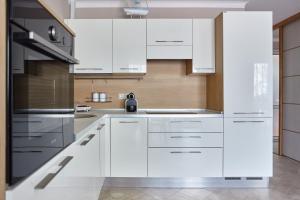 a kitchen with white cabinets and stainless steel appliances at GREEN HILL 2 Apartmani with POOL in Gornji Orahovac