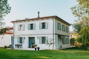 a white house with a green yard at Saranto, Maison du charme - Nel cuore verde dell'Emilia in Carpi