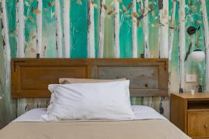 a bedroom with a bed with a wooden headboard at Saranto, Maison du charme - Nel cuore verde dell'Emilia in Carpi
