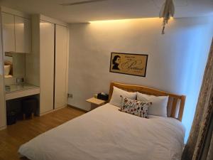 a small bedroom with a bed with white sheets at The Stay Christmas in Jeju