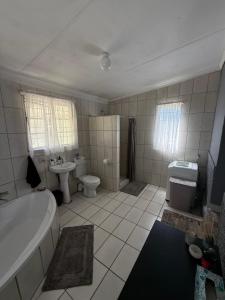 a bathroom with a tub and a toilet and a sink at Noir & Blanc in Parys