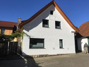 a man standing in front of a white building at Ferienwohnung ANEXE in Tecklenburg