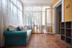 un salon avec un canapé bleu devant une fenêtre dans l'établissement GREEN HILL 2 Apartmani with POOL, à Gornji Orahovac