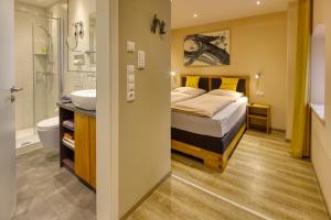 a bedroom with a bed and a shower and a sink at AD1716 apARTments Marktheidenfeld in Marktheidenfeld