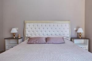 a bedroom with a large white bed with two night stands at GREEN HILL 2 Apartmani with POOL in Gornji Orahovac +21 photos
