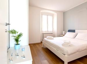 a white bedroom with a white bed and a window at Your Sea Escape in Riva Trigoso