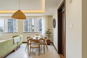 ein Esszimmer mit Tisch und Couch in der Unterkunft Diamond Ivy Two Bedroom Apartment, Swimming pool, gym, workspace ,Wonderiss Homes Kileleshwa Living in Nairobi