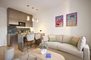 a living room with a couch and a kitchen at Le XV Cannes in Cannes