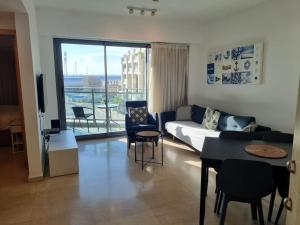 a living room with a couch and a table and chairs at חדר שינה וסלון ומרפסת נוף לים in Herzliyya B