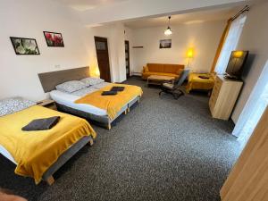 pokój hotelowy z dwoma łóżkami i kanapą w obiekcie Centrum Noclegi w mieście Krynica Zdrój