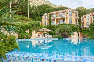 a swimming pool with chairs and a building at GREEN HILL 2 Apartmani with POOL in Gornji Orahovac
