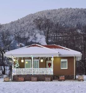 a house with christmas lights on it in the snow at OAZA in Mokra Gora