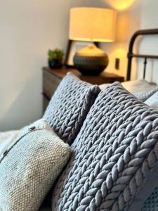 a bed with two pillows and a table with a lamp at Stunning Coastal Retreat Whitley Bay Sleeps 9 in Whitley Bay