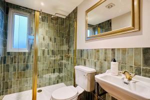 a bathroom with a toilet and a sink and a mirror at Stunning Coastal Retreat Whitley Bay Sleeps 9 in Whitley Bay +72 photos