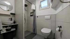 a white bathroom with a toilet and a sink at Ferienwohnung Azur in Selce