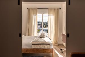a bedroom with a bed and a large window at Outsite Vilamoura - Work, Connect, Explore in Quarteira