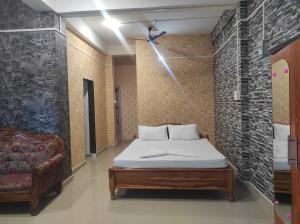 a bedroom with a bed and a couch in it at Rani Guest House in Gauhāti