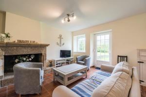ein Wohnzimmer mit Couch und Kamin in der Unterkunft Charmante maison la Tissanderie a Saint-Carreuc in Saint-Carreuc