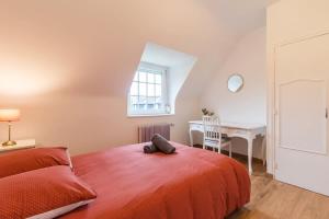 ein Schlafzimmer mit einem Bett, einem Schreibtisch und einem Tisch in der Unterkunft Charmante maison la Tissanderie a Saint-Carreuc in Saint-Carreuc